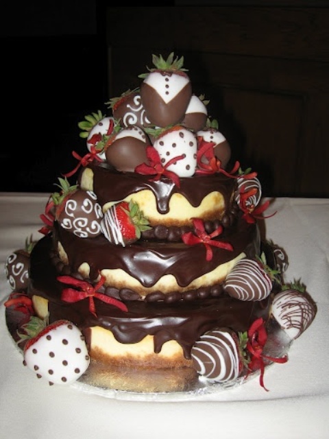 a wedding tiered cheesecake topped with dark chocolate drip and chocolate covered strawberries is a very whimsy option