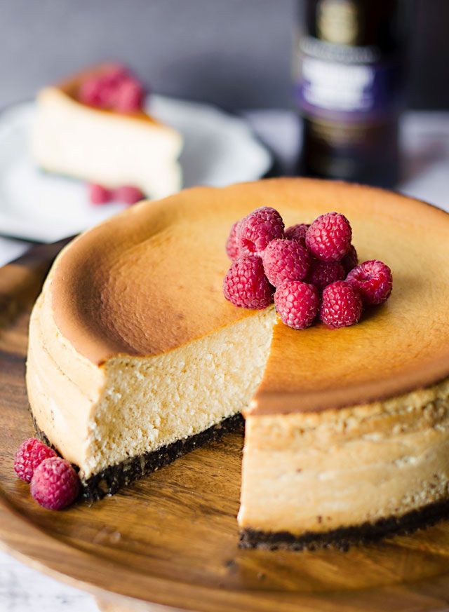 A large wedding cheesecake with chocolate base topped with fresh raspberries