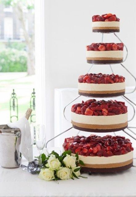 an assortment of delicious wedding cheesecakes in various sizes with fresh strawberries on top