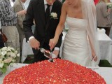 a giant heart-shaped wedding cheesecake covered with strawberries and white chocolate